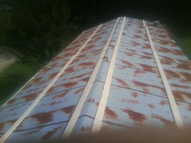 Rusted metal roof panels with new wood purlins before replacement — Storm Damage Roof Repair in Watauga by Roofing Brothers