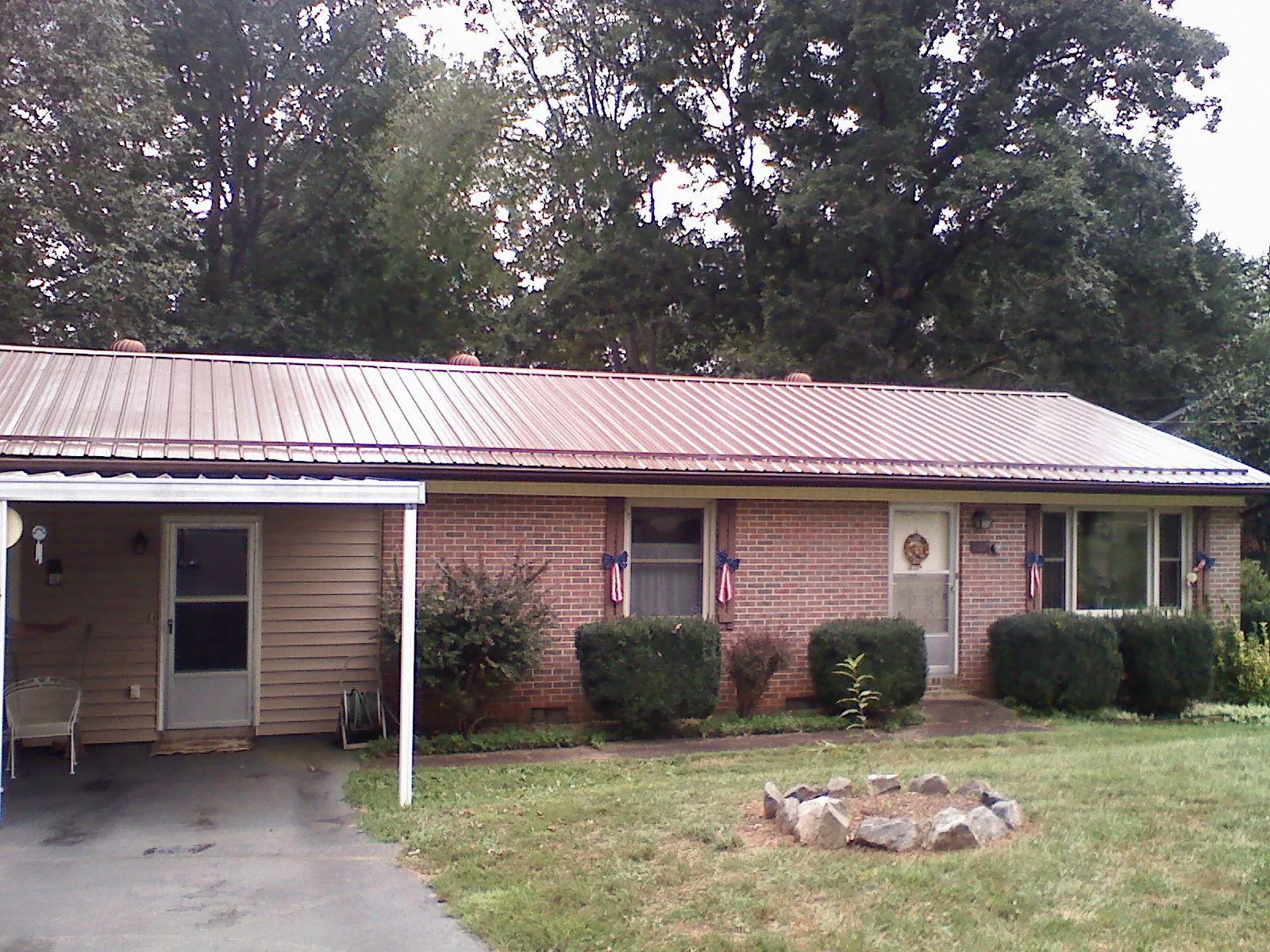 Bronze metal roof and carport on a brick ranch home — Roof Repair work by our crew in Watauga